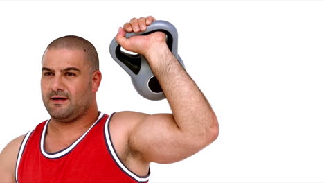 Determined-man-lifting-heavy-kettlebell