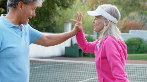 Senior-couple-giving-high-five-in-tennis-court-4k