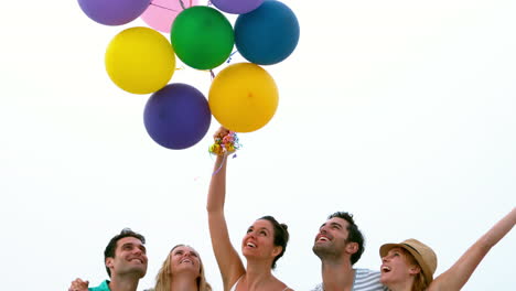 Lächelnde-Freunde-Die-Luftballons-Halten