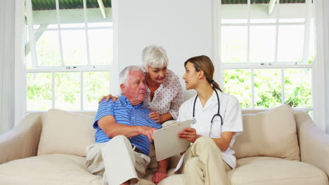 Nurse-doing-a-health-check-up-with-mature-man-on-a-sofa