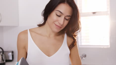 Portrait-of-a-brown-woman-smiling-and-doing-the-ironing