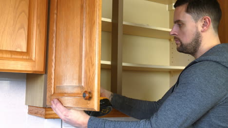 Man-fixing-the-cupboard