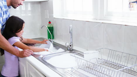 A-father-is-teaching-his-daughter-to-wash-the-dishes