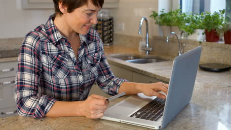 Mujer-Usando-Computadora-Portátil-Mientras-Sostiene-La-Tarjeta-De-Crédito