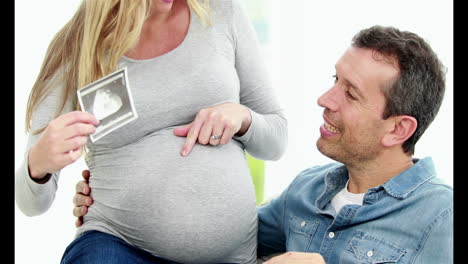 Mujer-Embarazada-Sonriente-Sentada-Sobre-Su-Marido