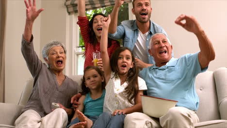 Mehrgenerationenfamilie-Auf-Dem-Sofa-Jubelt-Vor-Dem-Fernseher