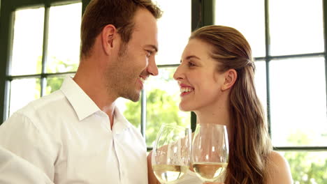 Couple-toasting-with-white-wine-in-restaurant
