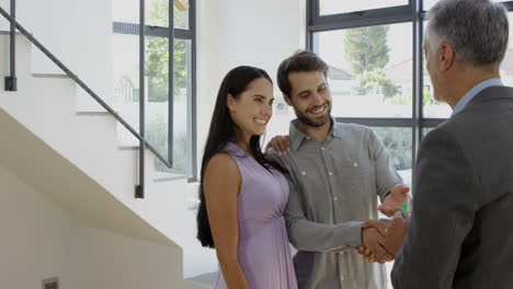 -Real-estate-agent-giving-keys-to-couple