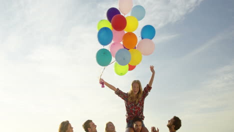 Freunde-Tanzen-Mit-Ballons-Im-Sand