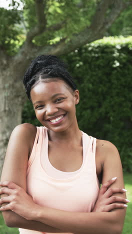 Vertical-video:-African-American-woman-standing,-arms-crossed,-smiling-at-home