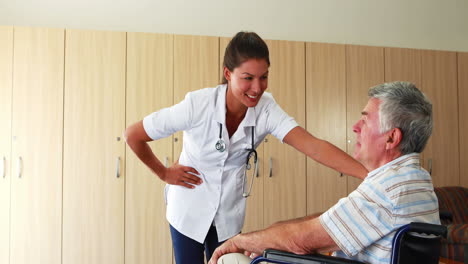 Krankenschwester-Spricht-Mit-Einem-älteren-Mann,-Der-In-Seinem-Rollstuhl-Sitzt