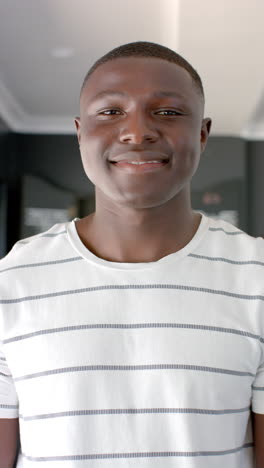 Vertical-video:-A-young-African-American-man-is-smiling-at-the-camera