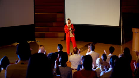 Happy-mature-Caucasian-hijab-businesswoman-standing-on-stage-in-business-seminar-4k