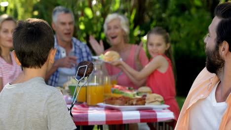 Family-is-congratulating-a-cute-boy-because-of-he-prepared-the-barbecue