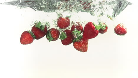 Strawberries-splashing-into-water-in-super-slow-motion