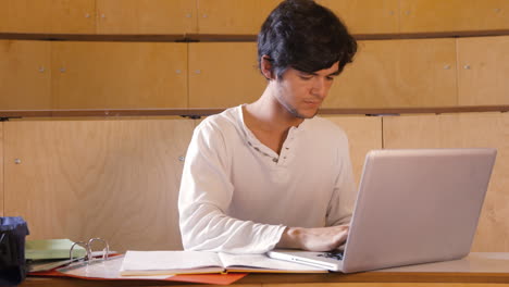 Handsome-student-taking-notes-on-computer