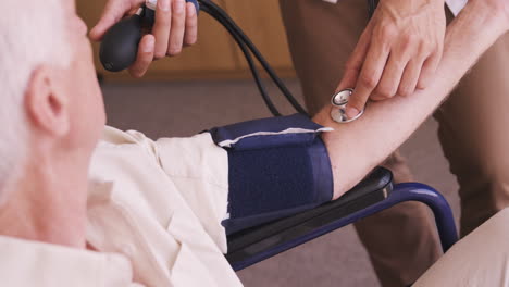 Male-doctor-checking-blood-pressure-of-senior-man