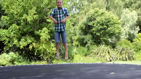 Portrait-of-cute-boy-jumping-on-the-trampoline-and-waving