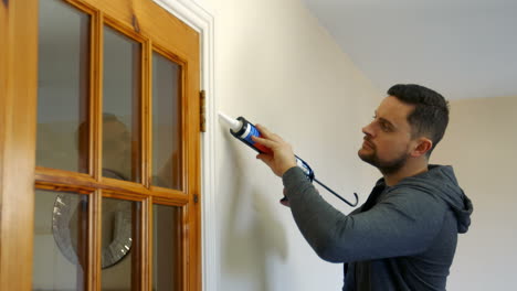 Handyman-filling-in-tiles-at-door