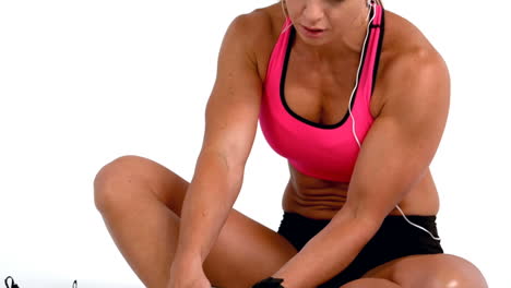 Injured-female-athlete-sitting-and-touching-ankle