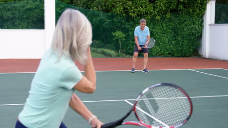 Pareja-Mayor-Jugando-Tenis-En-La-Cancha-De-Tenis-4k