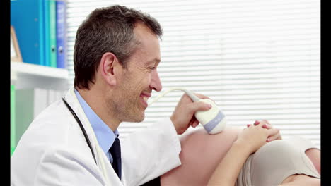 Male-doctor-doing-ultrasound-test-on-pregnant-woman