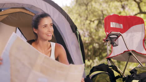 Woman-looking-at-a-map-outside-the-tent