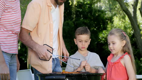 Süße-Familie-Bereitet-Einen-Grill-Im-Garten-Vor-