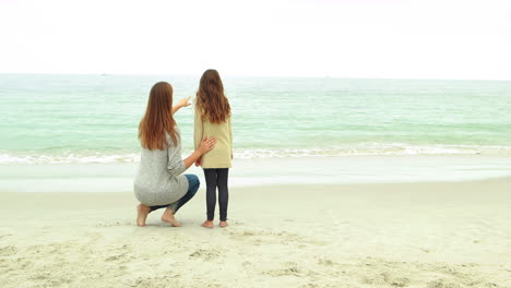 Mother-and-daughter-looking-at-beach