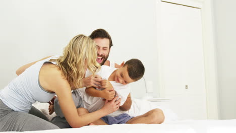 Glückliche-Familie-Spielt-Zusammen-Auf-Einem-Bett
