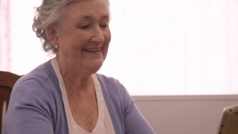 Smiling-senior-woman-using-digital-tablet