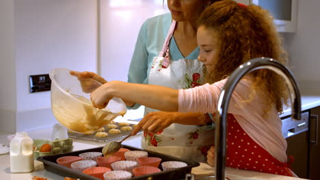 Mother-and-daughter-are-cooking-cupcakes-together-