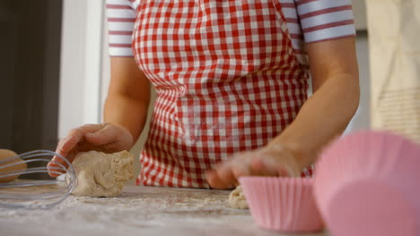 Woman-forming-balls-with-dough