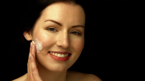 Smiling-woman-applying-cream