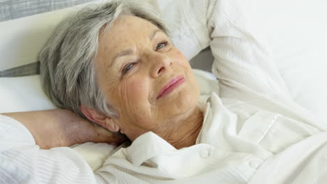 Senior-woman-relaxing-on-bed