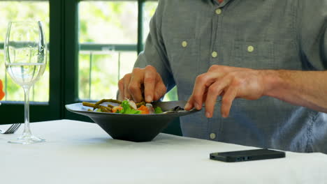 Man-tasting-his-dish-and-using-smartphone
