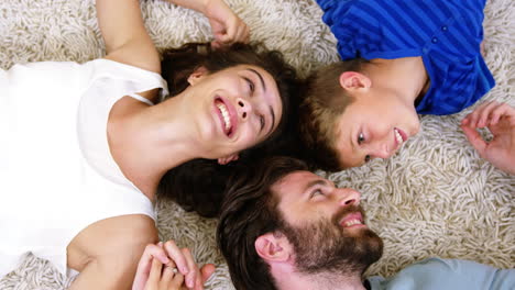 Familia-Feliz-Sonriendo-Y-Tumbada-En-Una-Alfombra