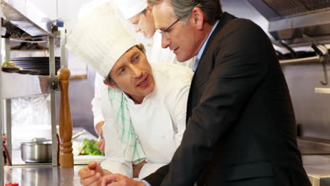 Man-and-chef-looking-at-a-clipboard