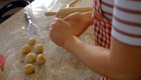 Woman-forming-balls-with-dough