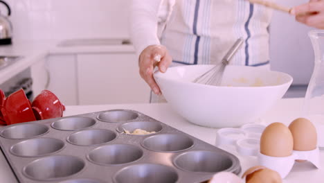 Woman-putting-dough-in-muffin-mold