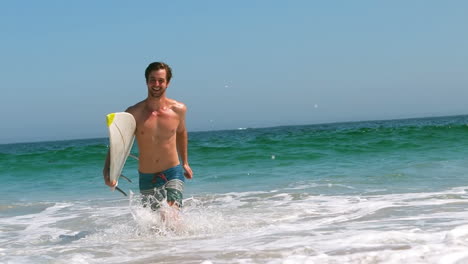 Man-getting-out-of-water-with-surfboard