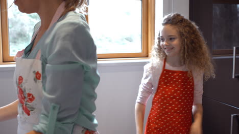 Mother-and-daughter-preparing-cookies-in-kitchen