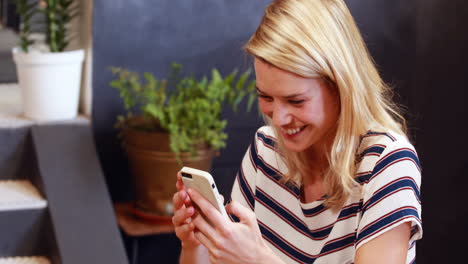 Mujer-Rubia-Sonriente-Usando-Un-Teléfono-Inteligente