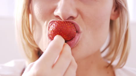 Close-up-on-a-blonde-woman-eating-a-strawberry