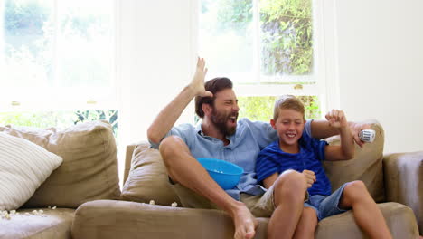 Padre-Feliz-Con-Hijo-Disfrutando-Frente-Al-Televisor