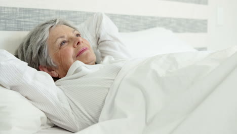 Senior-woman-relaxing-on-bed