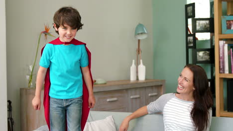 A-little-boy-pretending-to-be-a-superhero-while-his-mother-is-watching-him