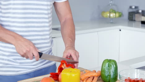 Man-cutting-vegetables-on-a-wooden-board