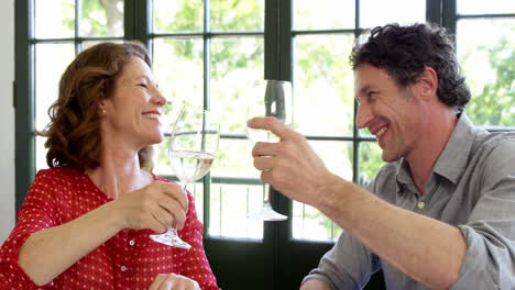 Cute-couple-having-lunch-and-toasting-with-wine