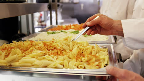 Chefs-Sirviendo-Bandejas-De-Pasta.